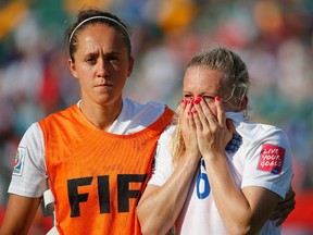 Laura Bassett of England is comforted by Jo Potter after the FIFA Women's World Cup semifinal match between Japan and England at the Commonwealth Stadium on July 1, 2015 in Edmonton, Canada.
