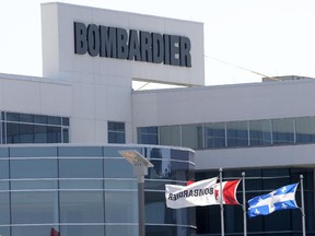 Flags fly outside a Bombardier plant in Montreal, Thursday, May 14, 2015. Bombardier, one of the world's biggest manufacturers of planes and trains, said Thursday it will cut about 1,750 employees in Montreal, Toronto and Ireland over the coming months because of weak demand for its largest business jets.