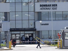 People walk outside a Bombardier plant in Montreal, Thursday, May 14, 2015.