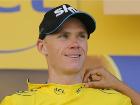 Britain's Christopher Froome, wearing the overall leader's yellow jersey, celebrates on the podium after the eleventh stage of the Tour de France cycling race over 188 kilometers (116.8 miles) with start in Pau and finish in Cauterets, France, Wednesday, July 15, 2015.