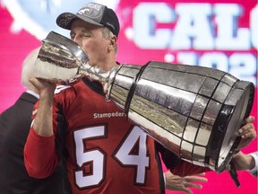 Calgary Stampeders head coach John Hufnagel kisses the Grey Cup after defeating the Hamilton Tiger-Cats in the 102nd Grey Cup in Vancouver in November 2014.