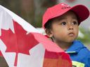 A young boy holds a flag as he watches the annual Canada Day parade in Montreal, Wednesday, July 1, 2015.