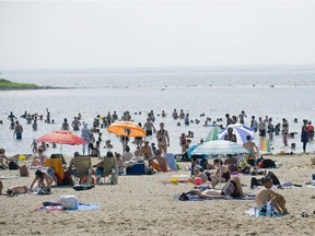People relax on the beach at Cap Saint Jacques nature park in Pierrefonds.