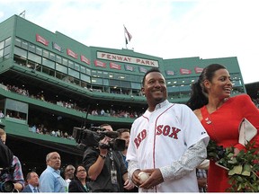 Pedro Martinez, a former member of the Boston Red Sox and Montreal Expos, and his wife Carolina leave the field after a ceremony to retire Martinez's number 45,  before a game with the Chicago White Sox at Fenway Park on July 28, 2015 in Boston, Mass.