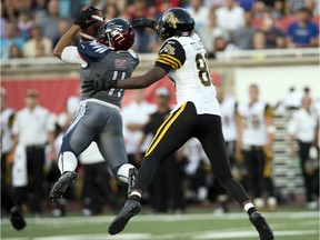 Montreal Alouettes linebacker Chip Cox (11) intercepts a pass intended for Hamilton Tiger-Cats wide receiver Terrence Toliver (80) during first quarter CFL action Thursday, July 16, 2015 in Montreal.