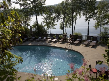 Guests enjoy a drink by the pool at Manoir Hovey, overlooking Lake Massawippi in the Eastern Townships.