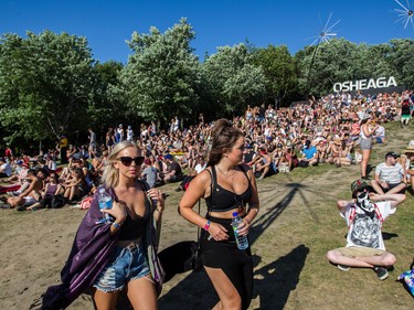 Music fans walk through the site of the 2015 edition of the Osheaga Music Festival at Jean-Drapeau park in Montreal on Friday, July 31, 2015.