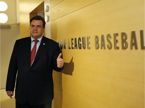 Montreal Mayor Denis Coderre poses for a photograph beside Major League Baseball's logo after a press conference following a private meeting with baseball Commissioner Rob Manfred at MLB headquarters in New York, Thursday, May 28, 2015.  The Mayor is seeking to bring a baseball team back to Montreal.