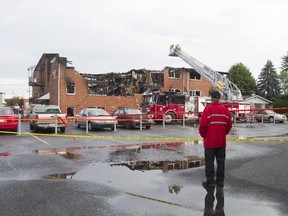 An emergency service worker surveys the remains of an apartment building that was gutted by a fatal fire in Drummondville, east of Montreal.