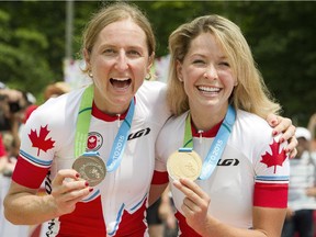 Canadians Catharine Pendrel, right, and Emily Batty with their silver and gold medals at the Hardwood Mountain Bike Park in Oro-Medonte, Ont., where they finished second and first, respectively in the women's mountain bike event at the Toronto 2015 Pan Am Games on Sunday, July 12, 2015.