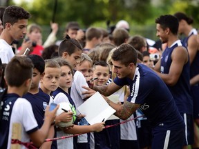 Paris Saint-Germain's French midfielder Blaise Matuidi (C) signs autographs after a training session at Saputo stadium in Montreal on July 30, 2015 two days ahead of French Trophy of Champions football match against Lyon.