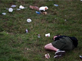 A heavy metal rock fan sleeps on the grass at the 2010 Heavy MTL Festival .