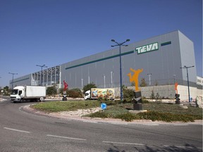 This Wednesday, Oct. 16, 2013 file photo shows trucks run past Teva Pharmaceutical Logistic Center in the town of Shoam, Israel. Israel's Teva Pharmaceutical Industries Ltd. said Monday it is purchasing Dublin-based Allergan PLC's generic pharmaceuticals business for $40.5 billion, in what Israeli analysts called the largest-ever acquisition by an Israeli company.