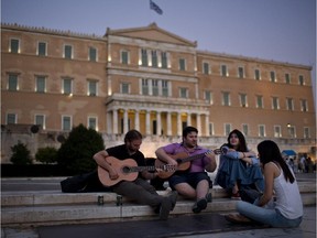 Greek men play guitars in front of the parliament in Athens, Thursday, July 2, 2015. The battle for Greek votes entered full swing Thursday ahead of a crucial weekend referendum that could decide whether the country falls out of the euro.