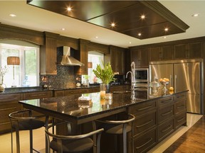 In the kitchen, the island and countertops are surfaced with a dark speckled granite that complements the cherry wood cabinets.