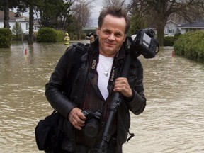Le Devoir photographer Jacques Nadeau is seen in this file photo working the Richelieu River floods Thursday, May 5, 2011 in Saint Blaise, Quebec. The 35-year veteran has had his life's work stolen which he says comprises of 30,000 - 50,000 photos of some of the most memorable events in Quebec's history.
