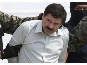 FILE - In this Feb. 22, 2014, file photo, Joaquin "El Chapo" Guzman, head of Mexico's Sinaloa Cartel, is escorted to a helicopter in Mexico City, following his capture overnight in the beach resort town of Mazatlan. Mexico's security commission said in a statement late Saturday, July 11, 2015, the top drug lord Joaquin 'El Chapo' Guzman has escaped from a maximum security prison, the second time he has fled after being captured.