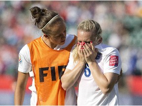 England's Josanne Potter (17) consoles Laura Bassett (6) after the loss to Japan in FIFA Women's World Cup semi-final soccer action in Edmonton on Wednesday July 1, 2015. Bassett gave up an own goal late in the game.