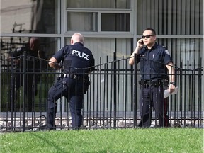 Police look over the scene where a young child died after falling 14 floors from a balcony at 71 Thorncliffe Park Drive Saturday evening.