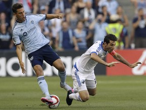 Sporting Kansas City forward Krisztian Nemeth, left, tackles the ball from Montreal Impact midfielder Ignacio Piatti during the first half of an MLS soccer match in Kansas City, Kan., Saturday, July 18, 2015.