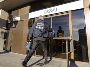 An agent from the Competition Bureau enters a building that houses the offices of Dessau, Tuesday November 6, 2012.