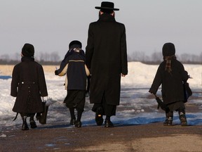 Male member of the Lev Tahor ultra-orthodox Jewish sect walks children home from school in Chatham, Ont. Monday, Feb. 3, 2014.