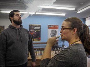 Manager Stacy Pomerleau and employee Josh Steingue vape at Robot Vapes in Montreal Wednesday Jan. 21, 2015.  Quebec health minister Gaetan Barrette has said that vaping should be tolerated.
