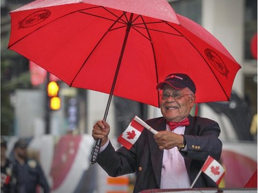 Dr. Roopnarine Singh, founder of the Montreal Canada Day parade in 1978, rides in the back of a convertible on Ste-Catherine St. during the 2015 version of the parade in Montreal Wednesday July 1, 2015.   Dr. Singh organized the parade for 26 years.
