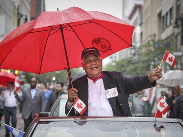 Dr. Roopnarine Singh, founder of the Montreal Canada Day parade in 1978, rides in the back of a convertible on Ste-Catherine St. during the 2015 version of the parade in Montreal Wednesday July 1, 2015.   Dr. Singh organized the parade for 26 years.