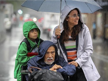 Rosario Fuentes watches the Canada Day parade with her son Ivan and father Jose on  Ste-Catherine St. at Peel in Montreal Wednesday July 1, 2015.  Mr. Fuentes is visiting Montreal from Chile.