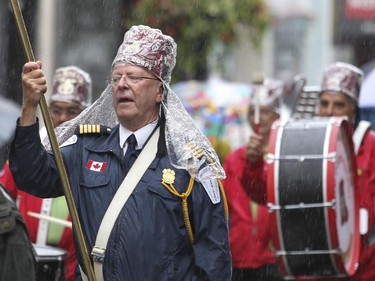 Shriners wear rain covers over their fezes during Canada Day parade on Ste-Catherine St. in Montreal Wednesday July 1, 2015.