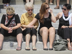 Left to right:  Louise and Jocelyne Couture, Kim Clusiault and Lynda Lemieux, family of victim Kathy Clusiault, attend a memorial event outside Paroisse Ste-Agnes in Lac-Mégantic on July 6, 2015, marking the second anniversary of the rail disaster that destroyed the town centre and killed 47 people.