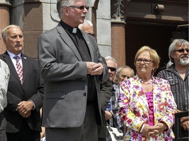 Mayor Colette Roy-Laroche listens to Fr. Gilles Baril during memorial event outside Paroisse Ste-Agnès in Lac-Mégantic, 250 kilometres east of Montreal Monday July 6, 2015 to mark the 2nd anniversary of the deadly rail disaster.