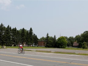 A cyclist rides past a vacant lot on De Lotbiniere in Vaudreuil-Dorion, the site where low-cost housing units  will be built.