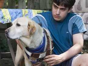 Benjamin Cukier-Houde puts on harness on his Mira dog Alaska, in the backyard of their home in Montreal on Wednesday July 15, 2015.