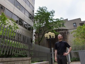 Dr. Raphael Fischler, associate professor and director of the School of Urban Planning at McGill University, poses for a photograph outside the Maison Alcan complex, in downtown Montreal on Sunday, July 19, 2015. After being sold to new owners, part of the complex will be demolished to create space for a high-rise building.