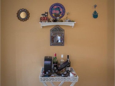 Wall hangings and table of liquor in the hallway of Iris Fisher's home.