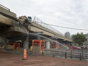 Workers tear down a section of the inbound Bonaventure Expressway in Montreal, Tuesday, July 21, 2015.