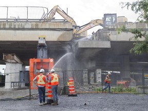 Workers tear down a section of the inbound Bonaventure Expressway .