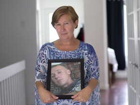 Carol Lynn Blair holds a portrait of her son Patrick in her Laval home, July 22, 2015. On June 16, eight months after going missing, Patrick's body was found in the river behind the trees he ran into.