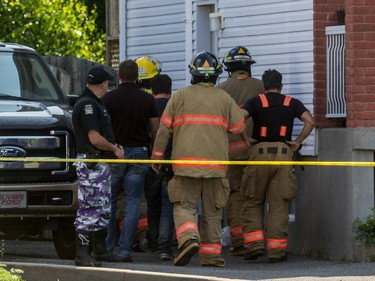 Firefighters enter a home where three bodies were foundon de Blois Street in Boucherville, July 3, 2015.