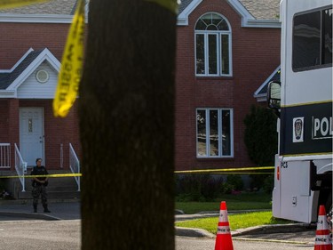 Police investigate after three bodies were found inside a home on de Blois Street in Boucherville, July 3, 2015.