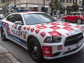 Police car plastered with stickers at the corner of Peel St. at de Maisonneuve Blvd. in July 2015.