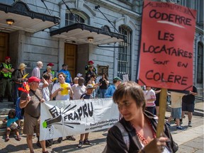 A woman holds a sign reading "Coderre, renters are angry" during a demonstration organized by FRAPRU, July 6, 2015.