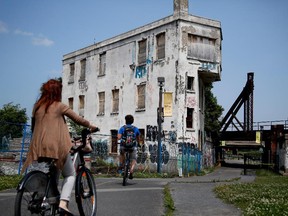 Cyclist ride along the Lachine Canal in front of the Wellington Tower ion Wednesday July 8, 2015.