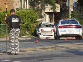 Police at the scene of an accident in which a taxi driver died after his car collided with another car, in Montreal,  July 8, 2015.