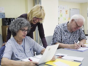 Rossana Bruzzone coaches students Nicole Perrier and Louis-Michel Goulet during an optimistic writing class at the Milton Park Recreation Association on June 16, 2015.