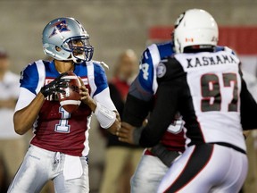 MONTREAL, QUE.: JUNE 25, 2015-- Montreal Alouettes quarterback Brandon Bridge, left, looks for an open man as Ottawa Redblacks defensive lineman Kalonji Kashama closes in on him during CFL action at the Percival Molson Stadium in Montreal on Thursday June 25, 2015. The Redblacks beat the Alouettes 20-16.(Allen McInnis / MONTREAL GAZETTE)