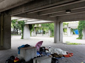 A homeless person sleeps in the sheltered section of Charles Daudelin's Viger Square public art installation, Agora, in Montreal on Friday June 5, 2015. The Agora has been a preferred place for homeless to seek shelter and set up squatter camps since it opened in the 1980s. The city is planning a major facelift of the square.