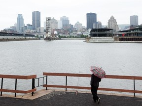 A man fishes, overlooking the Montreal skyline.